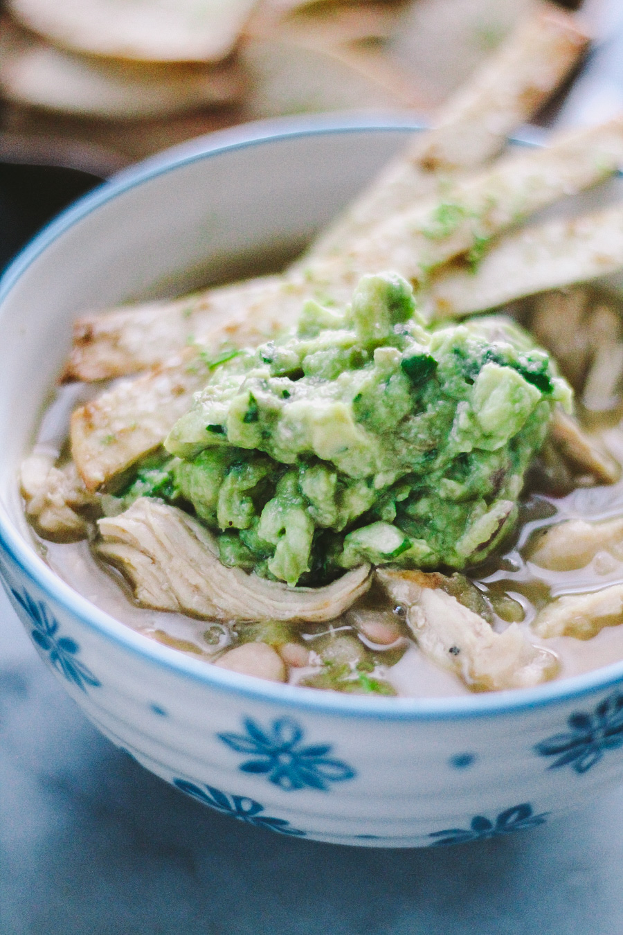 white chili via playswellwithbutter | packed with flavor from a carefully built base of onions, chili peppers, & warm spices, this white chili is braised with beer, loaded with pulled roasted chicken breast, & thickened with masa harina. oh, & if that didn't win you over, spoonfuls of white chili make for the perfect vessel for guacamole. #boom.