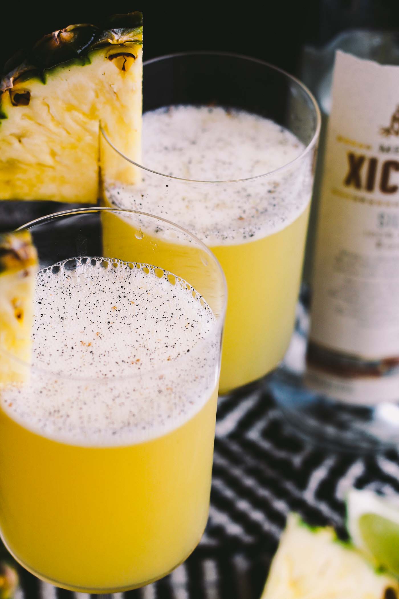 smoky pineapple mezcal margaritas with vanilla bean are the perfect fun cocktail to celebrate cinco de mayo! the smoke & bite of good mezcal is balanced with the natural sweetness of pineapple juice & vanilla bean. | cinco de mayo party, margarita recipe, mezcal, easy cocktail recipe, cocktail, summer drink, party drink |
