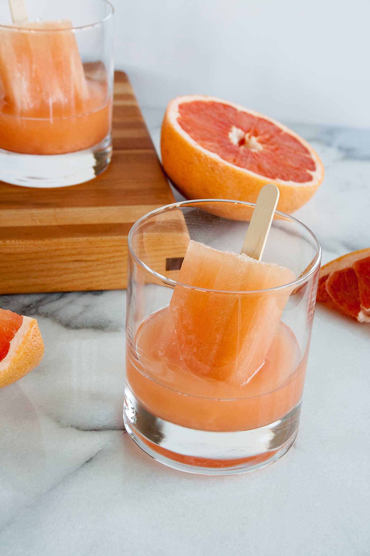 greyhound boozy popsicles are perfect for summer! tart fresh grapefruit juice is balanced by a homemade rosemary simple syrup, these alcohol popsicles are going to be your new go-to for summer entertaining! | summer drinks, homemade alcohol popsicle recipe, boozy popsicle recipe, girls night, summer party, greyhound cocktail, vodka cocktail |