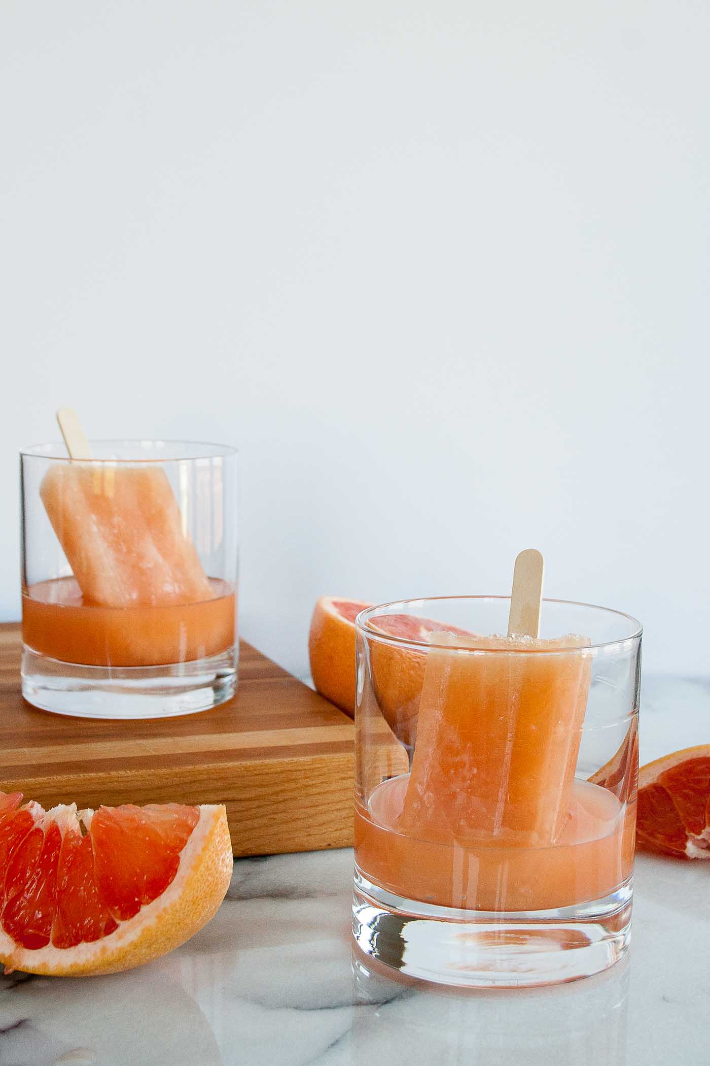 greyhound boozy popsicles are perfect for summer! tart fresh grapefruit juice is balanced by a homemade rosemary simple syrup, these alcohol popsicles are going to be your new go-to for summer entertaining! | summer drinks, homemade alcohol popsicle recipe, boozy popsicle recipe, girls night, summer party, greyhound cocktail, vodka cocktail |