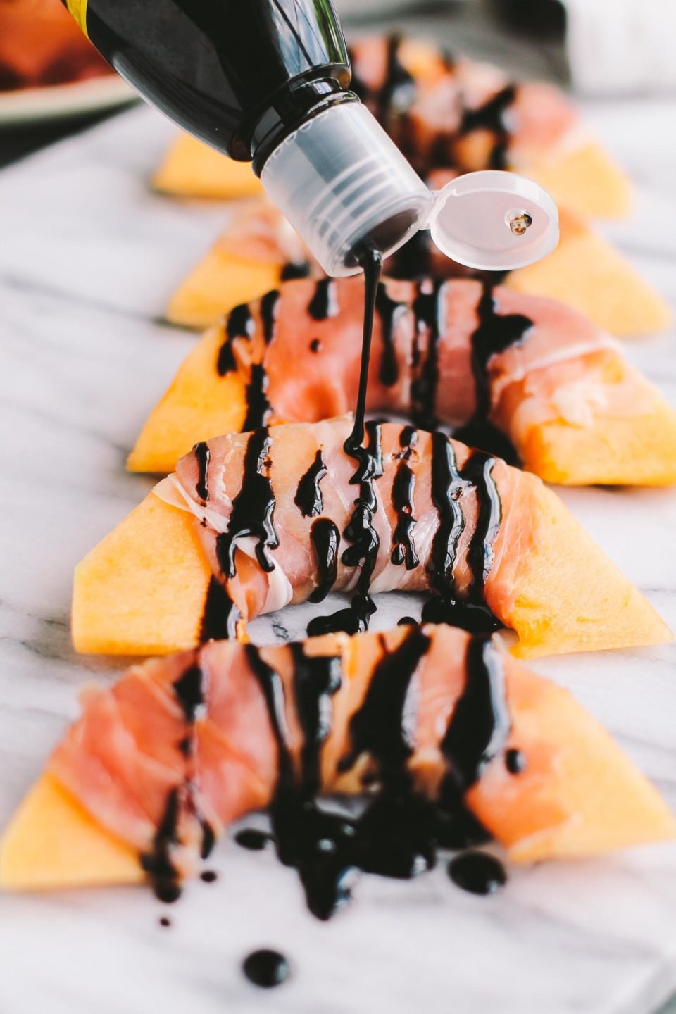 a three-ingredient recipe for prosciutto wrapped cantaloupe topped with balsamic glaze. this appetizer is perfectly balanced, super simple, & most importantly - so delicious! prosciutto-wrapped cantaloupe with balsamic glaze are perfect for summer parties & easy entertaining on hot summer nights. | prosciutto, easy appetizer for a crowd, summer food, summer party, healthy appetizer recipe, make ahead appetizer, girls night recipe, date night recipe |