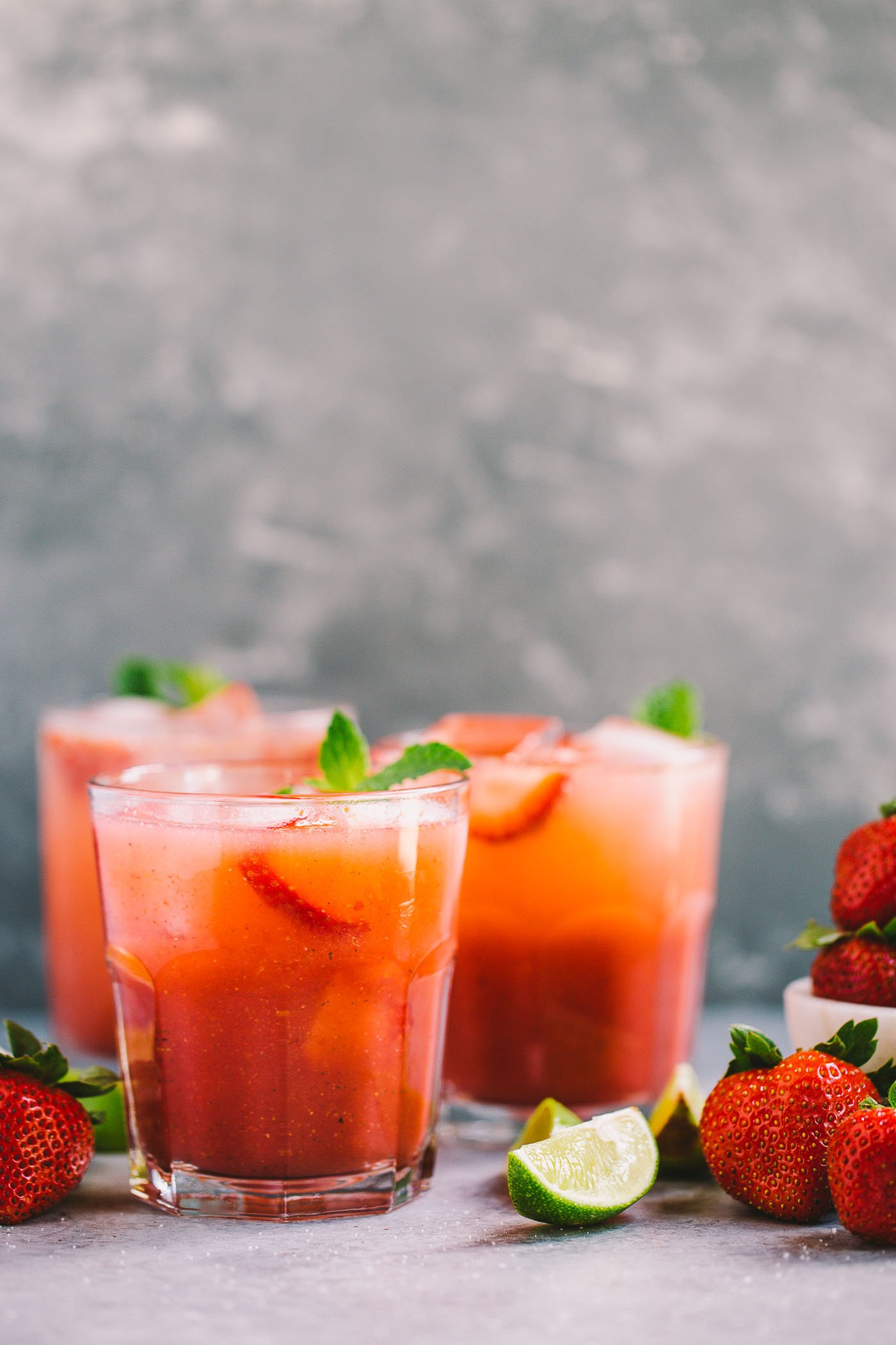classic mojitos get a spicy strawberry twist in this easy cocktail recipe for spicy strawberry mojitos! fresh strawberries muddled with lime juice, mint, & spicy rum for the perfectly balanced spicy & sweet cocktails. these spicy strawberry mojitos will be your new favorite! #mojitos #easycocktail #cocktailrecipe #strawberrymojitos #spicystrawberrymojitos #playswellwithbutter