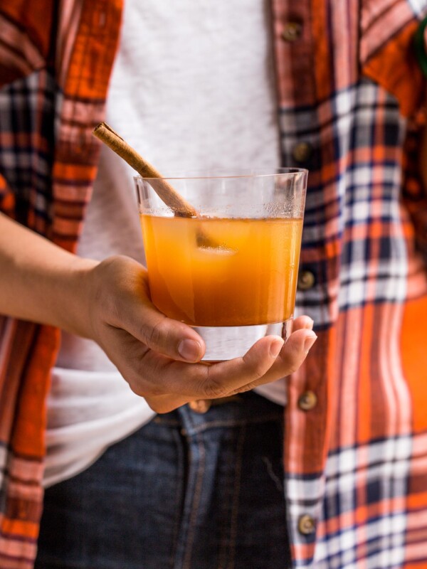 easy & cozy bourbon ginger cider cocktails perfect for autumn! the bold flavor of a nice bourbon is perfectly balanced out by warming notes of a good apple cider & ground cinnamon, the spice of a strong ginger beer, & the bright tang of fresh lime. you will love making these bourbon ginger cider cocktails for your friends & family all autumn long! #playswellwithbutter #easycocktailrecipe #bourbon #autumncocktail #fallcocktail