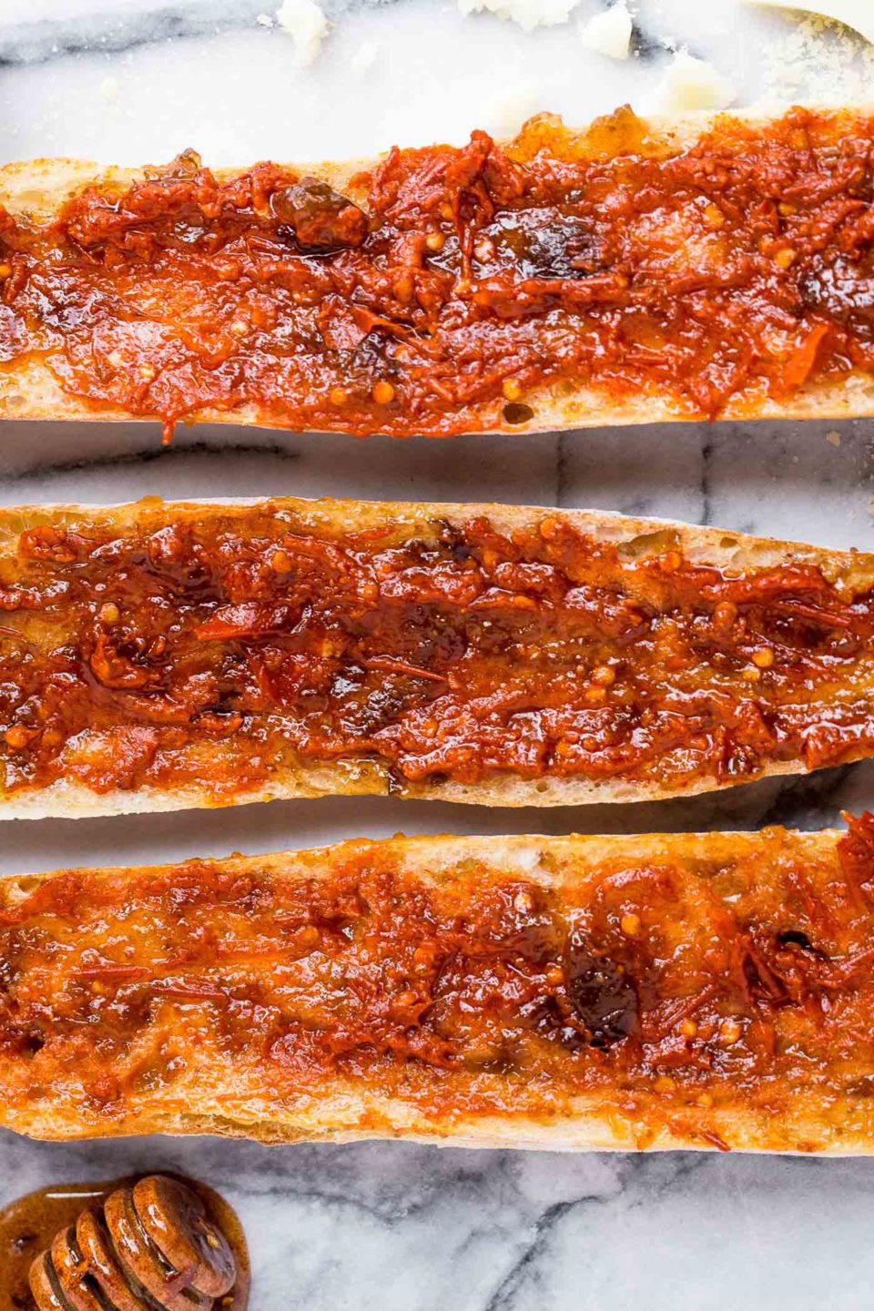 easy chorizo french breads with manchego, fig spread, & harissa, & covered in big fat drizzles of homemade spicy paprika honey. an easy & elegant appetizer! an easy & elegant appetizer or snack, perfect for holiday entertaining! #playswellwithbutter #chorizo #harissa #manchego #holidayparty #cocktailparty #appetizer