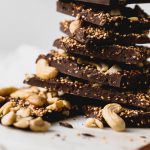a simple & healthy three-ingredient dark chocolate bark recipe with toasted quinoa folded throughout a thick layer of dark chocolate and topped with cashews. this superfood dark chocolate bark has it all - plant-based protein, antioxidants, & healthy fats - what more could you want out of a healthy little on-the-go snack or dessert? #darkchocolatebark #chocolatebarkrecipe #healthychocolatebark #healthydessert #superfoodsnacks #healthysnack #toastedquinoa #cashews #darkchocolate