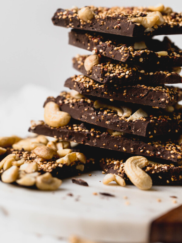 a simple & healthy three-ingredient dark chocolate bark recipe with toasted quinoa folded throughout a thick layer of dark chocolate and topped with cashews. this superfood dark chocolate bark has it all - plant-based protein, antioxidants, & healthy fats - what more could you want out of a healthy little on-the-go snack or dessert? #darkchocolatebark #chocolatebarkrecipe #healthychocolatebark #healthydessert #superfoodsnacks #healthysnack #toastedquinoa #cashews #darkchocolate