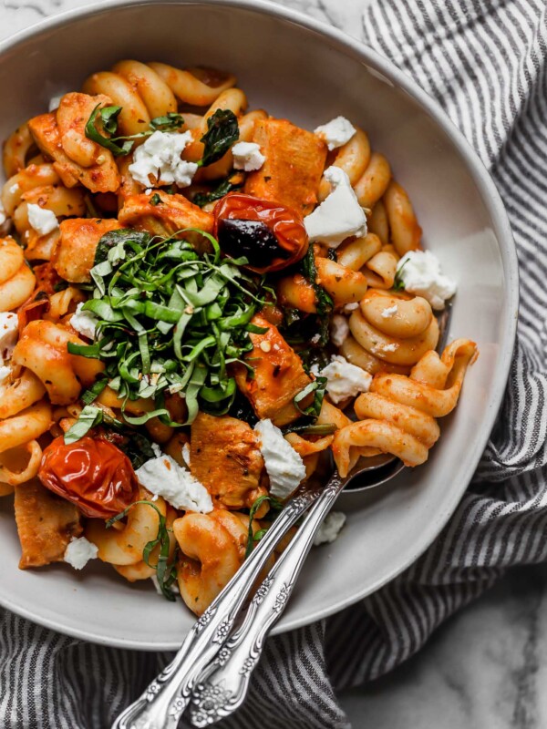 date night pasta pomodoro with chicken & goat cheese is the perfect easy pasta dinner recipe! made with chicken, spinach, goat cheese, and a homemade roasted red pepper pomodoro sauce, this pasta pomodoro with chicken & goat cheese is on your table in 25 minutes or less, tastes totally fresh, & is perfect for date night! #playswellwithbutter #easypastarecipe #pastapomodoro #pastadinner #italianrecipe