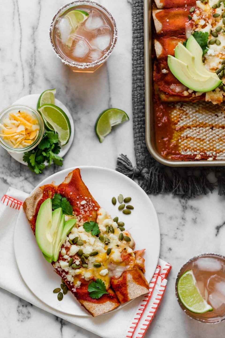 an easy & healthy chicken enchilada recipe perfect for weeknight cooking! these weeknight chicken enchiladas have a filling of pulled chicken, bell pepper sweet onion, black beans, & cheese, and get covered in the easiest blender enchilada sauce made from ancho chiles. the only thing missing is a couple of margaritas! #playswellwithbutter #chickenenchiladas #easychickenenchiladas #enchiladasrecipe #healthyenchiladas #mexicanfoodrecipes #homemadenchiladasauce #enchiladasaucerecipe #easydinnerrecipe #healthydinnerrecipe #mealpreprecipe