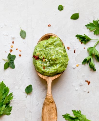 traditional chimichurri gets a fun twist with this easy 10-minute avocado chimichurri sauce recipe! made with tons of fresh herbs (cilantro, parsley, oregano), plenty of red wine vinegar, & avocado, this avocado chimichurri is tangy, flavorful, & SO creamy. perfect to top any grilled meats this summer, to spread on a sandwich, to serve as a dip, or to eat by the spoonful! vegan & whole30 compliant! #playswellwithbutter #avocadochimichurri #chimichurrisauce #veganrecipe #easyrecipe
