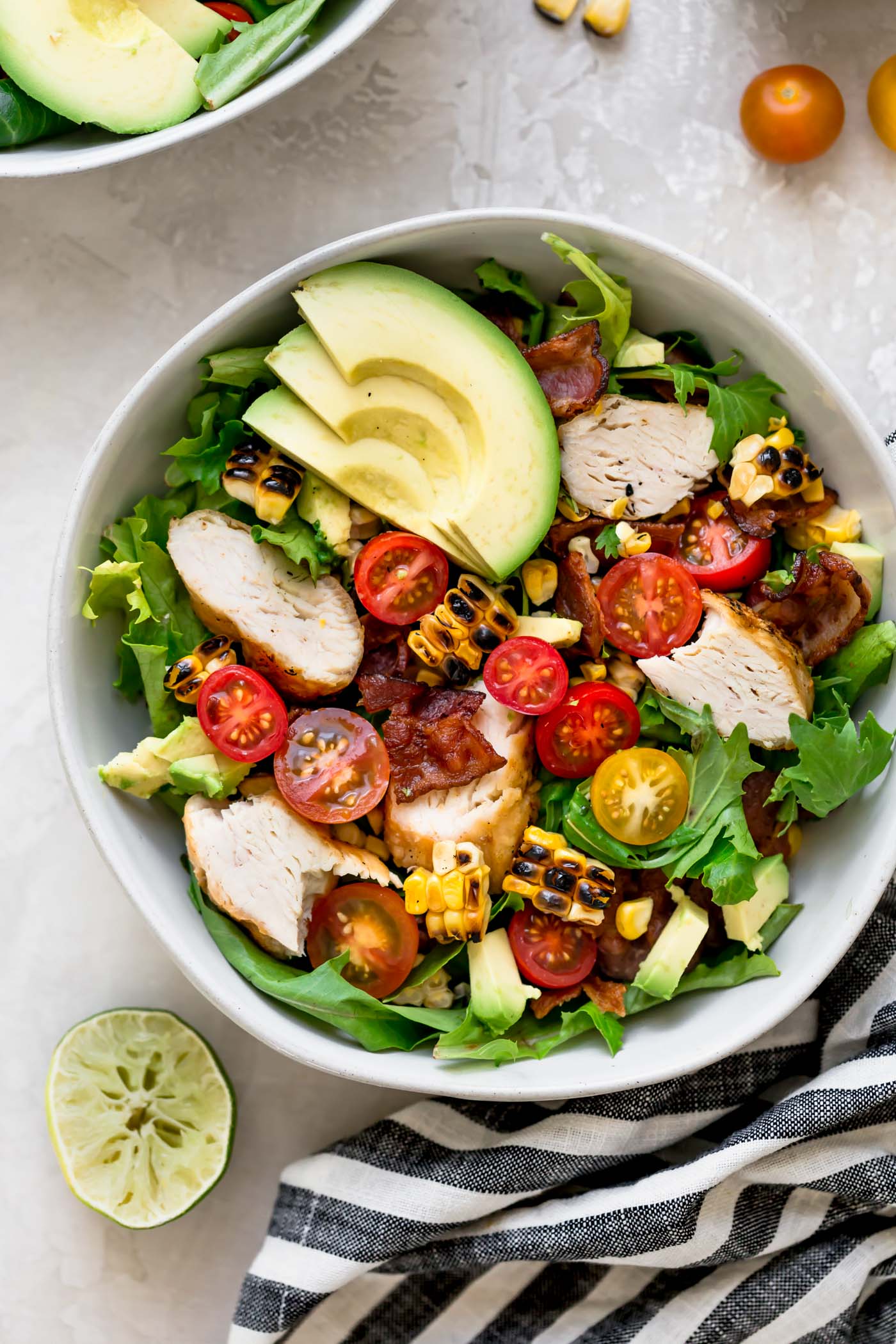 a light & fresh blt salad for summer loaded with bacon, cherry tomatoes, sweet corn, avocados, grilled chicken, & an easy cilantro basil vinaigrette. this blt salad recipe is hearty, but super fresh, making it the perfect easy summer dinner. naturally gluten-free & perfect for meal prep! #playswellwithbutter #bltsalad #saladrecipe #dinnersalad #summersalad #glutenfree #easyglutenfreerecipes