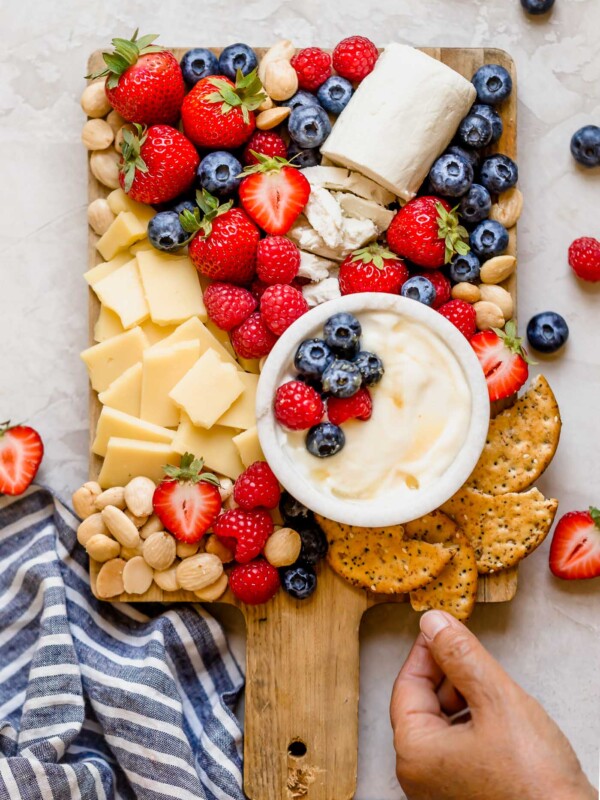 a summer berry cheese board filled with strawberries, raspberries, blueberries, & the perfect cheeses to pair with cheese boards. this summer berry cheese board is an easy & fun appetizer or snack to serve at parties & barbeques all summer long! #playswellwithbutter #summerberrycheeseboard #cheeseboard #summercheeseboard #cheeseboardidea #appetizer #appetizersforparty #easyappetizers #makeaheadappetizers
