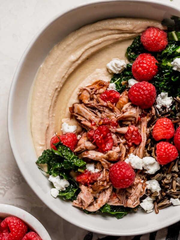 an easy one-skillet recipe for chipotle raspberry chicken, served overtop an autumn hummus bowl with creamy, garlicky hummus, finely shredded kale, wild rice, goat cheese, & some extra raspberries. chipotle raspberry chicken autumn hummus bowls are the perfect healthy & easy weeknight dinner, or an easy meal to prep for grab-&-go lunches this week! #hummusbowl #chipotleraspberrychicken #raspberryrecipes #raspberrydinnerrecipes #healthyrecipe #skilletrecipe #bowlrecipe #easyrecipe #mealprep
