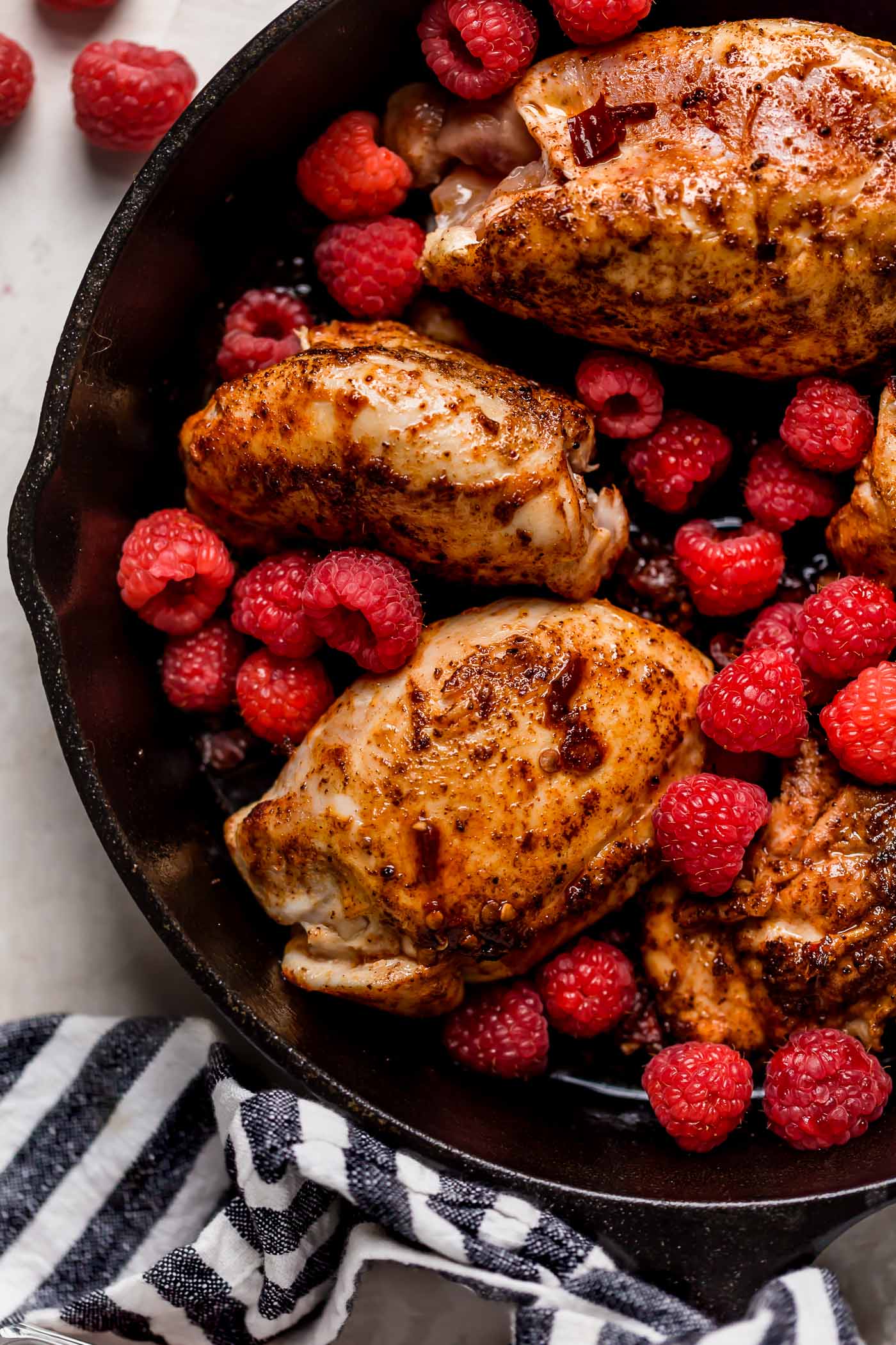 an easy one-skillet recipe for chipotle raspberry chicken, served overtop an autumn hummus bowl with creamy, garlicky hummus, finely shredded kale, wild rice, goat cheese, & some extra raspberries. chipotle raspberry chicken autumn hummus bowls are the perfect healthy & easy weeknight dinner, or an easy meal to prep for grab-&-go lunches this week! #hummusbowl #chipotleraspberrychicken #raspberryrecipes #raspberrydinnerrecipes #healthyrecipe #skilletrecipe #bowlrecipe #easyrecipe #mealprep