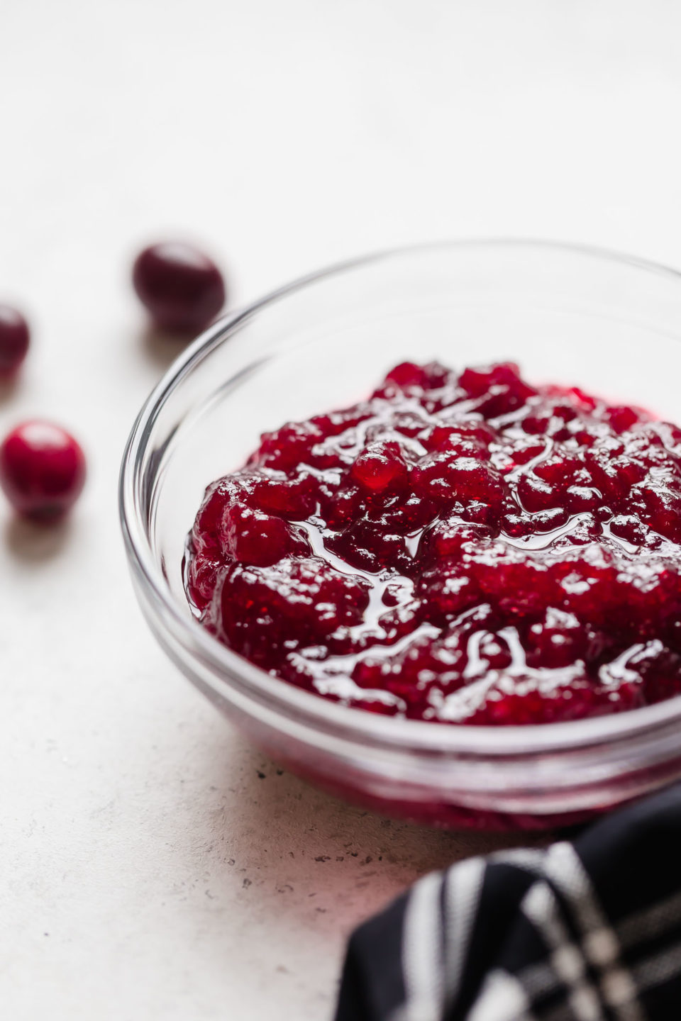 Whole berry cranberry sauce shown in a small glass mixing bowl.