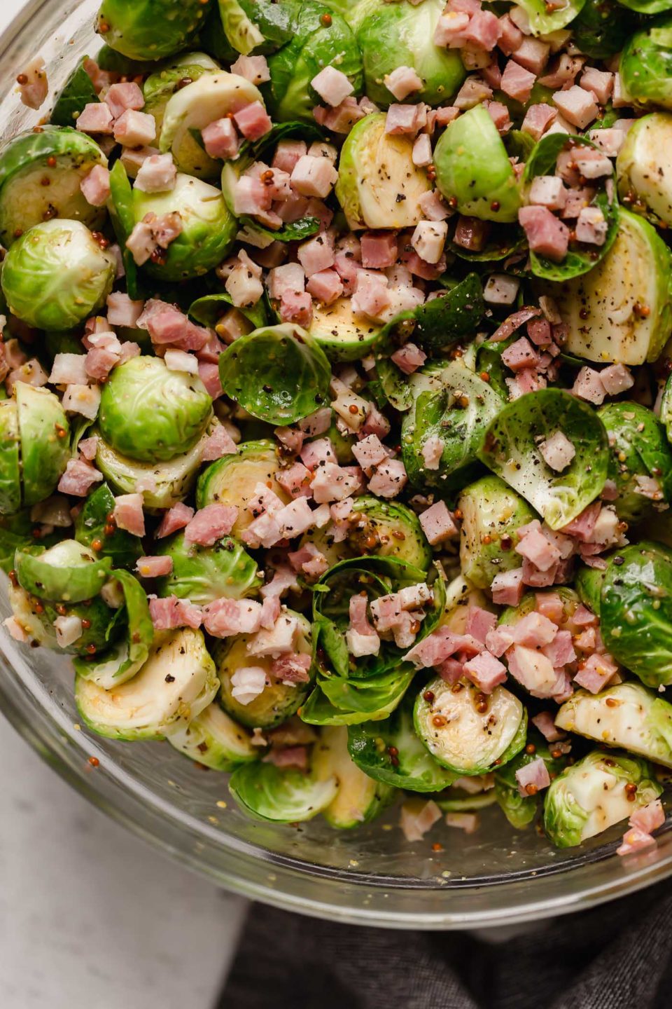 Brussels sprouts & pancetta in a large mixing bowl, tossed in the maple mustard roasting sauce.