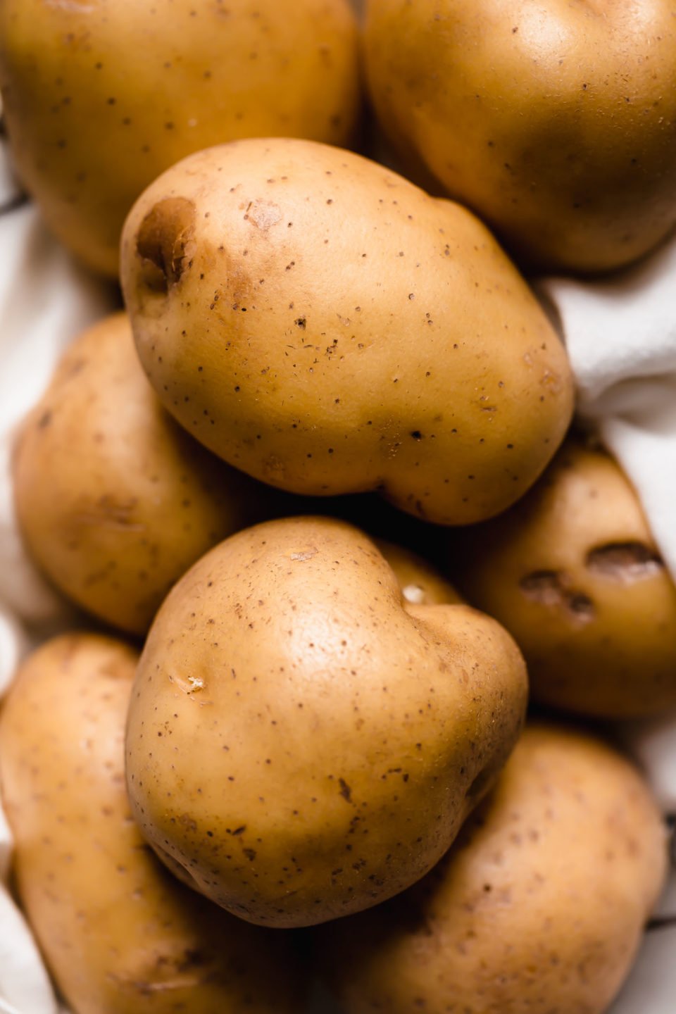 A pile of Yukon Gold potatoes for the best buttermilk mashed potatoes.
