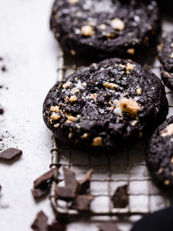 bittersweet chocolate cookies with caramelized white chocolate. intensely fudgy dark chocolate cookies made with black cocoa powder, filled with caramelized white chocolate chunks & bittersweet chocolate chunks & finished with flaky sea salt. these bittersweet chocolate cookies are dramatic, rich & decadent! #playswellwithbutter #cookierecipe #chocolatecookie #doublechocolatecookie #fudgychocolatecookie #blackcocoapowderrecipes #caramelizedwhitechocolate
