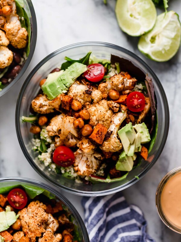 an easy roasted veggie vegan taco salad recipe! this plant-based taco salad is piled high with roasted cauliflower, sweet potatoes, & chickpeas, plus any other taco toppings you love, & served with a homemade smoky & creamy cashew vegan taco salad dressing that’s so good you’ll want to eat it by the spoonful! the perfect easy meatless monday dinner, or healthy lunch to meal prep for the week. #playswellwithbutter #vegantacosalad #healthytacosalad #vegansalad #veganrecipes #plantbasedrecipes