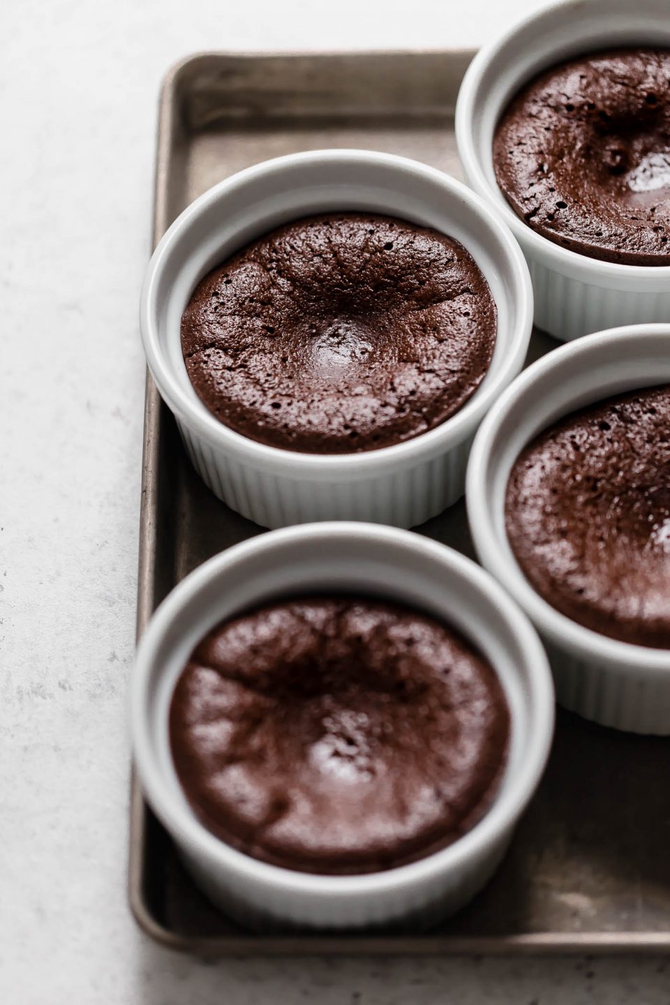the easiest mini flourless chocolate cake recipe, made with 5 ingredients. these individual flourless chocolate cakes are amazingly light & fudgy all at once. an impressive & elegant dessert for valentine’s day date nights or galentine’s gatherings! #playswellwithbutter #flourlesschocolatecake #individualflourlesschocolatecake #miniflourlesschocolatecake #easyflourlesschocolatecakerecipe #bestflourlesschocolatecakerecipe #valentinesdaydessert #datenightrecipe #girlsnightrecipe #chocolatedessert