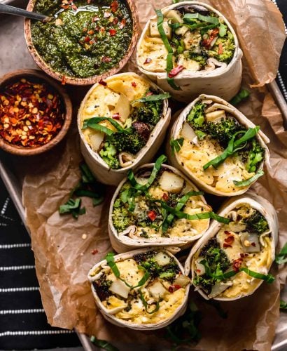 an easy vegetarian breakfast burritos recipe, filled with soft-scrambled eggs, cheese, roasted broccoli, mushrooms & potatoes, & a drizzle of fresh pesto for freshness. pesto roasted veggie vegetarian breakfast burritos are the perfect healthy make-ahead breakfast for weekdays! (meal prep & freezer-friendly) #breakfastburritos #vegetarianbreakfastburritos #easybreakfastburritos #makeaheadbreakfast #freezerbreakfastburritos #breakfastrecipes #makeaheadbreakfastrecipes #easybreakfastrecipes
