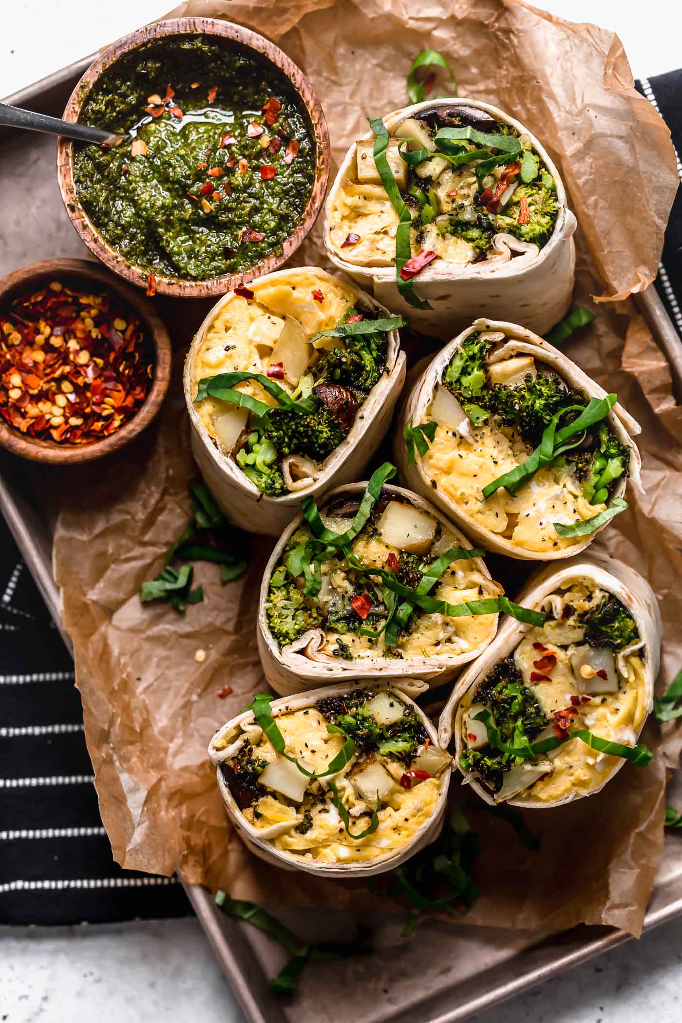 an easy vegetarian breakfast burritos recipe, filled with soft-scrambled eggs, cheese, roasted broccoli, mushrooms & potatoes, & a drizzle of fresh pesto for freshness. pesto roasted veggie vegetarian breakfast burritos are the perfect healthy make-ahead breakfast for weekdays! (meal prep & freezer-friendly) #breakfastburritos #vegetarianbreakfastburritos #easybreakfastburritos #makeaheadbreakfast #freezerbreakfastburritos #breakfastrecipes #makeaheadbreakfastrecipes #easybreakfastrecipes