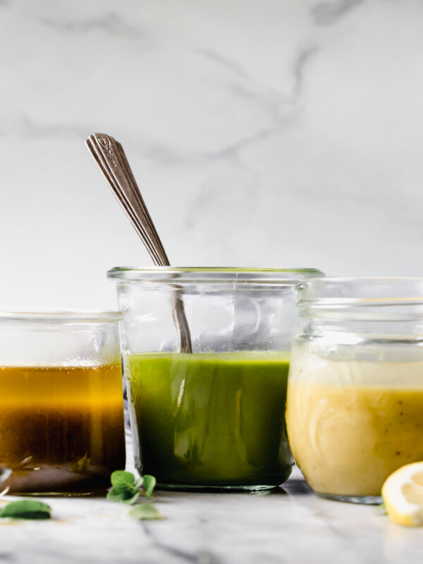 3 Staple Vinaigrettes in separate jars, sitting on marble surface.