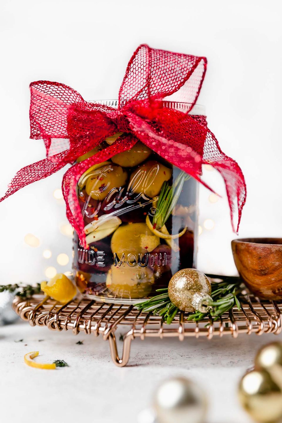 A jar of marinated olives with a big red bow tied around it as a hostess gift.