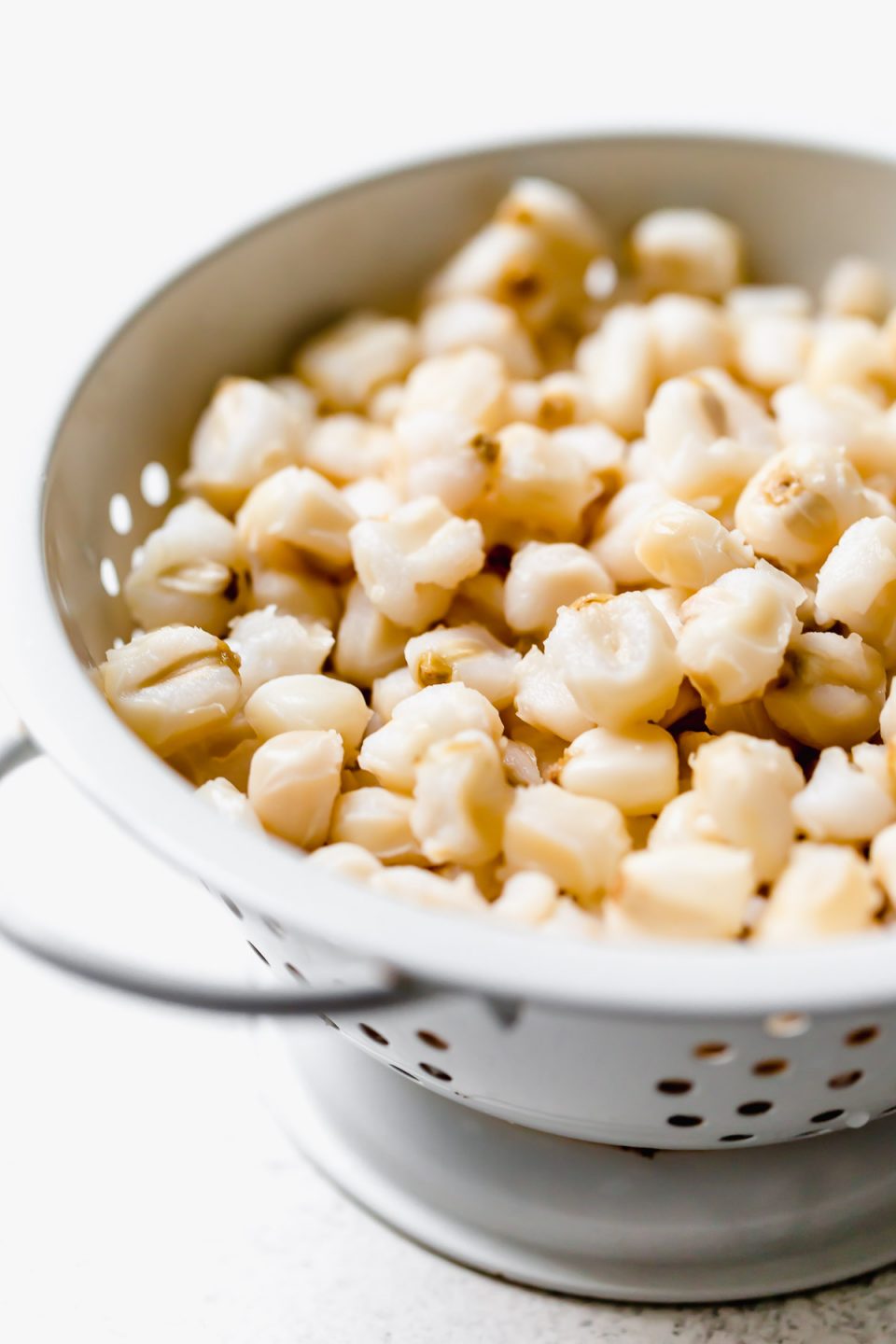 Hominy, sitting in a small white colander.