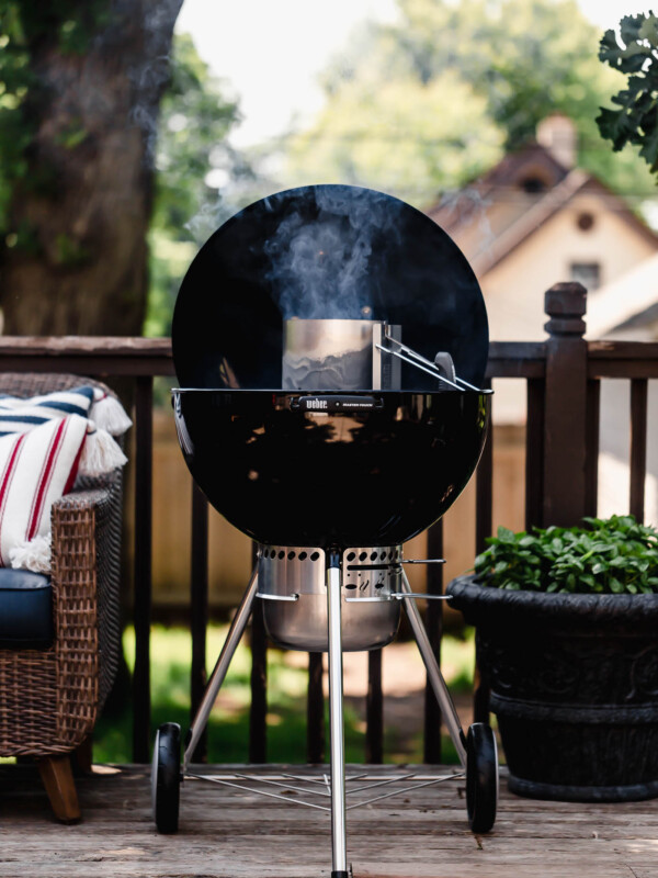 Weber Kettle Grill with lit Charcoal Chimney inside of it, showing how to light a charcoal grill.
