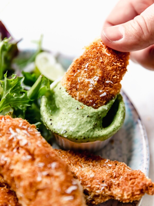Dunking a coconut chicken tender in cilantro-lime cashew crema.