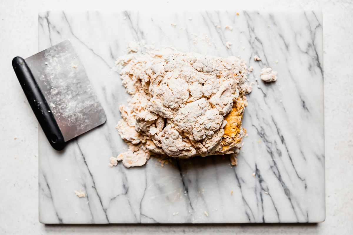 How to fold biscuit dough: pumpkin biscuit dough shown folded into thirds to create extra flaky layers.