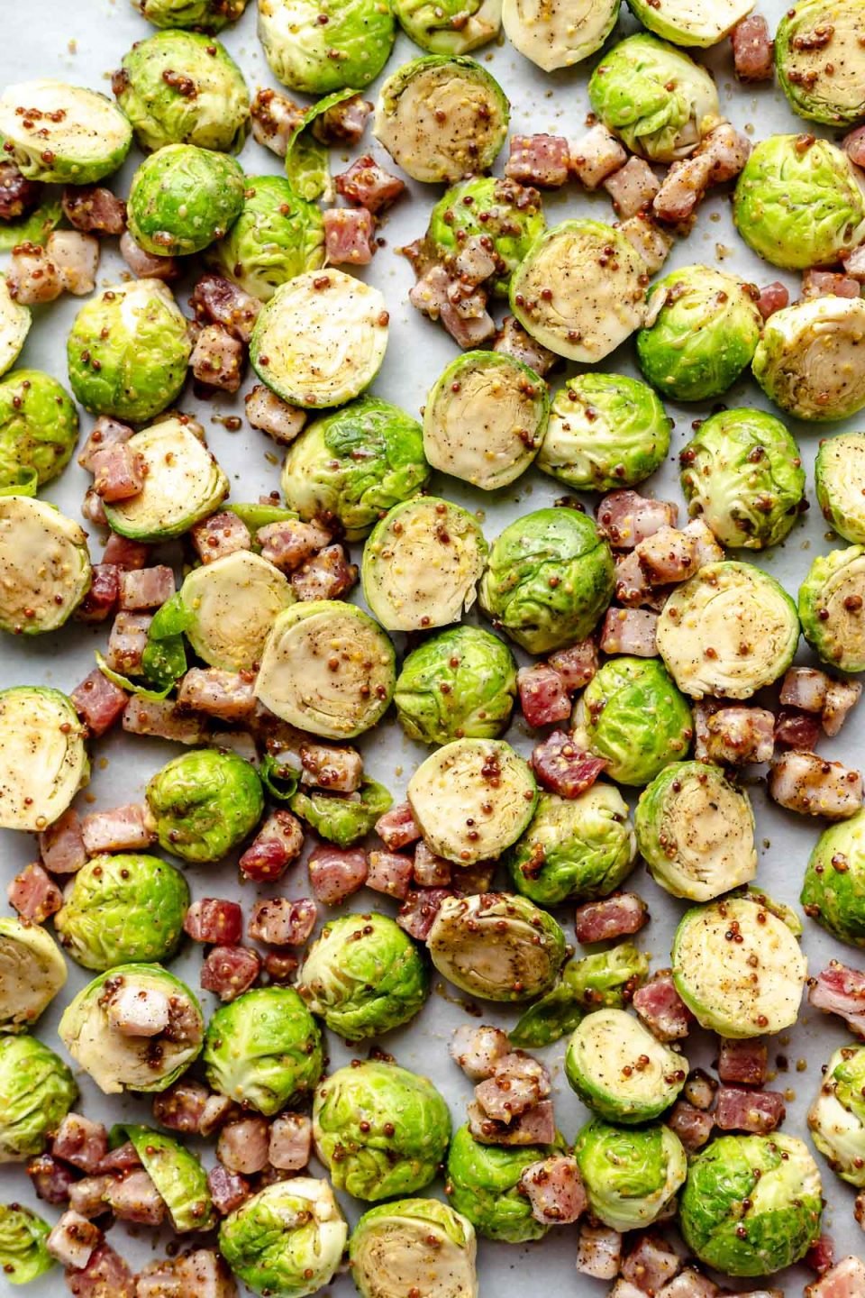 Brussels sprouts coated in Maple syrup & mustard, on a large baking sheet with dice pancetta.