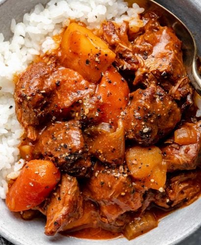 Hawaiian style beef stew over sticky rice in a large bowl.