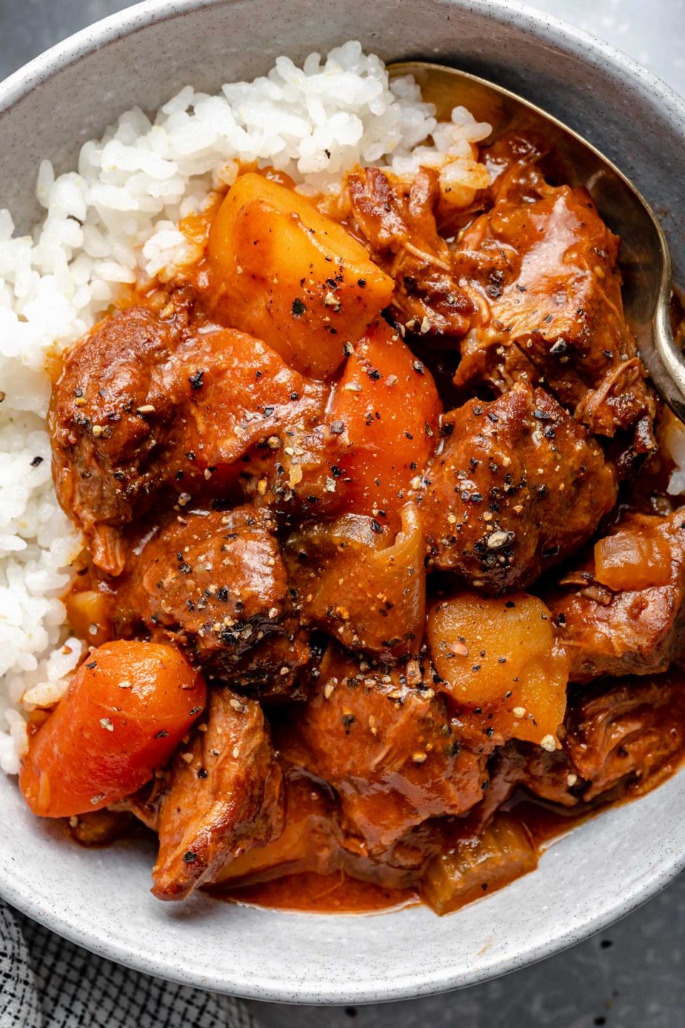 Hawaiian style beef stew over sticky rice in a large bowl.