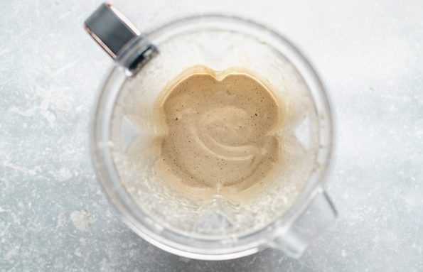 An overhead shot of blended Cilantro Lime Cashew Crema inside of an open high-speed blender carafe.