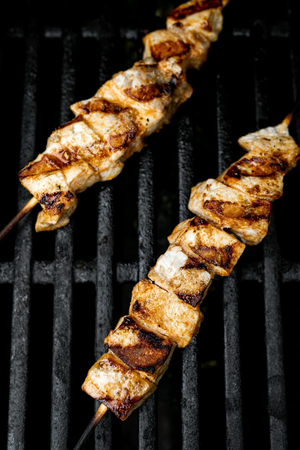 Swordfish kabobs on grill grates, with deep grill marks.