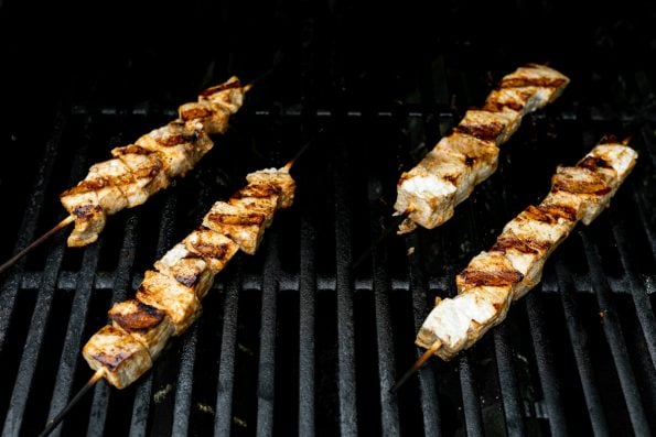 Swordfish kabobs on grill grates, with deep grill marks.