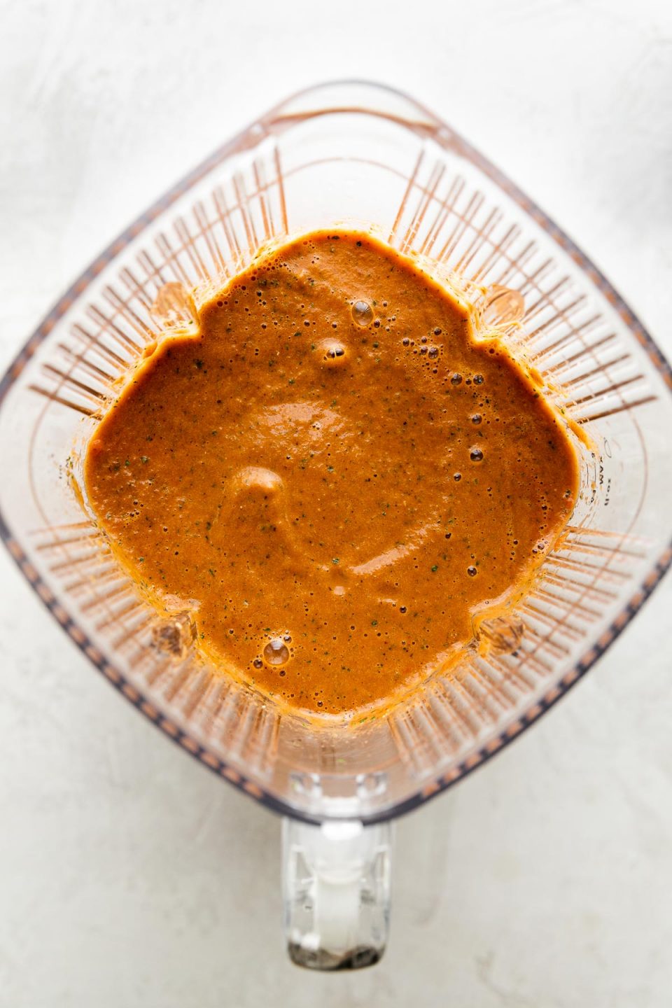 An overhead shot of blended Roasted Tomato basil Soup inside of a Zwilling Enfinigy Pro Blender carafe.