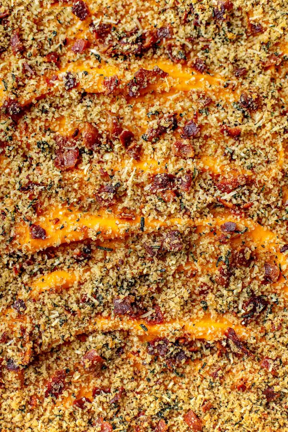 A close up shot of Savory Sweet Potato Casserole and its bacon breadcrumb topping.