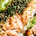 A close-up overhead macro shot of a partially eaten furikake salmon fillet with boy choy.