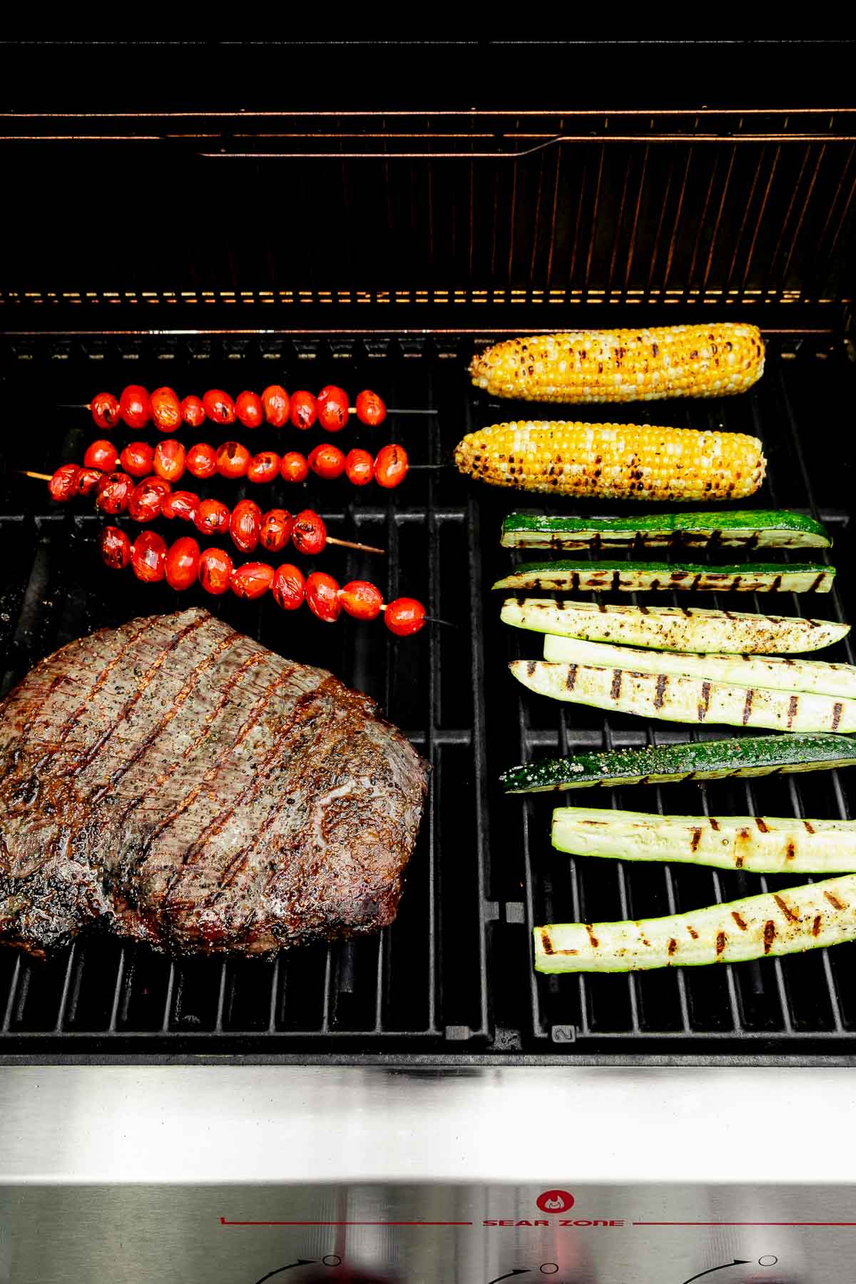 A shot of steak and vegetables being grilled over an open flame.