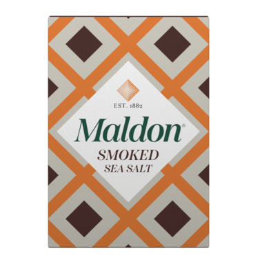 A box of Maldon Smoked Sea Salt featuring a geometric pattern with orange and brown diamonds and the brand name prominently displayed in the center.