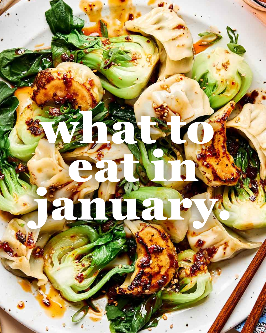 A plate with dumplings, grilled bok choy, and a spicy sauce, topped with sesame seeds and scallions. The text what to eat in january. is overlaid on the image.