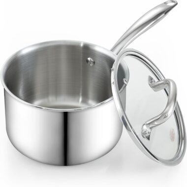 A stainless steel saucepan with a long handle and a clear glass lid, positioned slightly off to the side. The pot has a shiny, reflective surface and appears clean and unused.